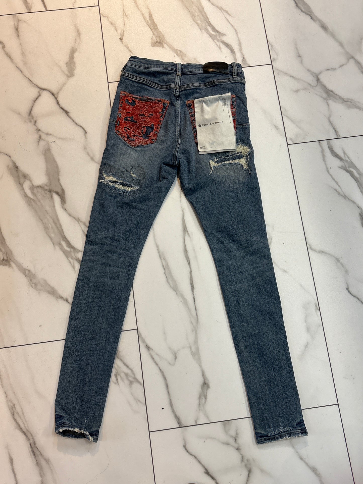 Purple jeans ripped with red tag